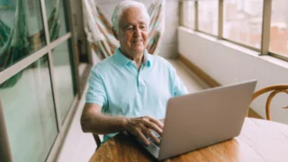 mężczyzna w wieku emerytalnym pracuje przy komputerze